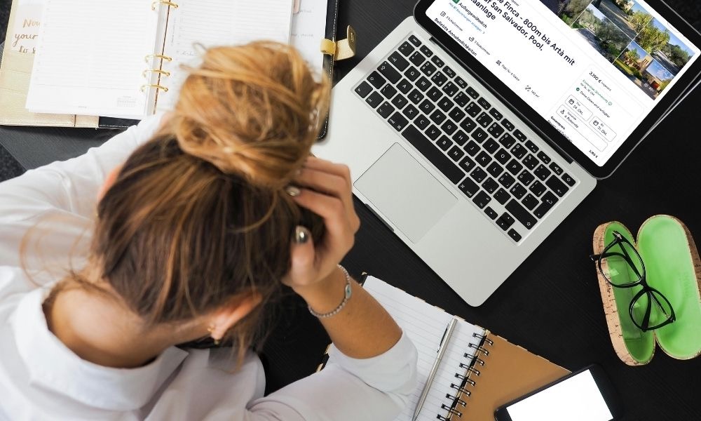 Verzweifelte Frau sitzt vor aufgeklapptem Laptop